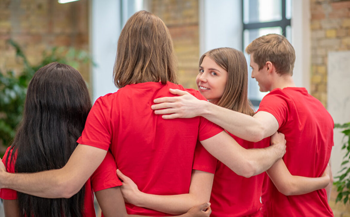 Team of young volunteers in red tshirt