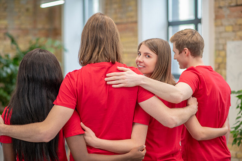 Team of young volunteers in red tshirt